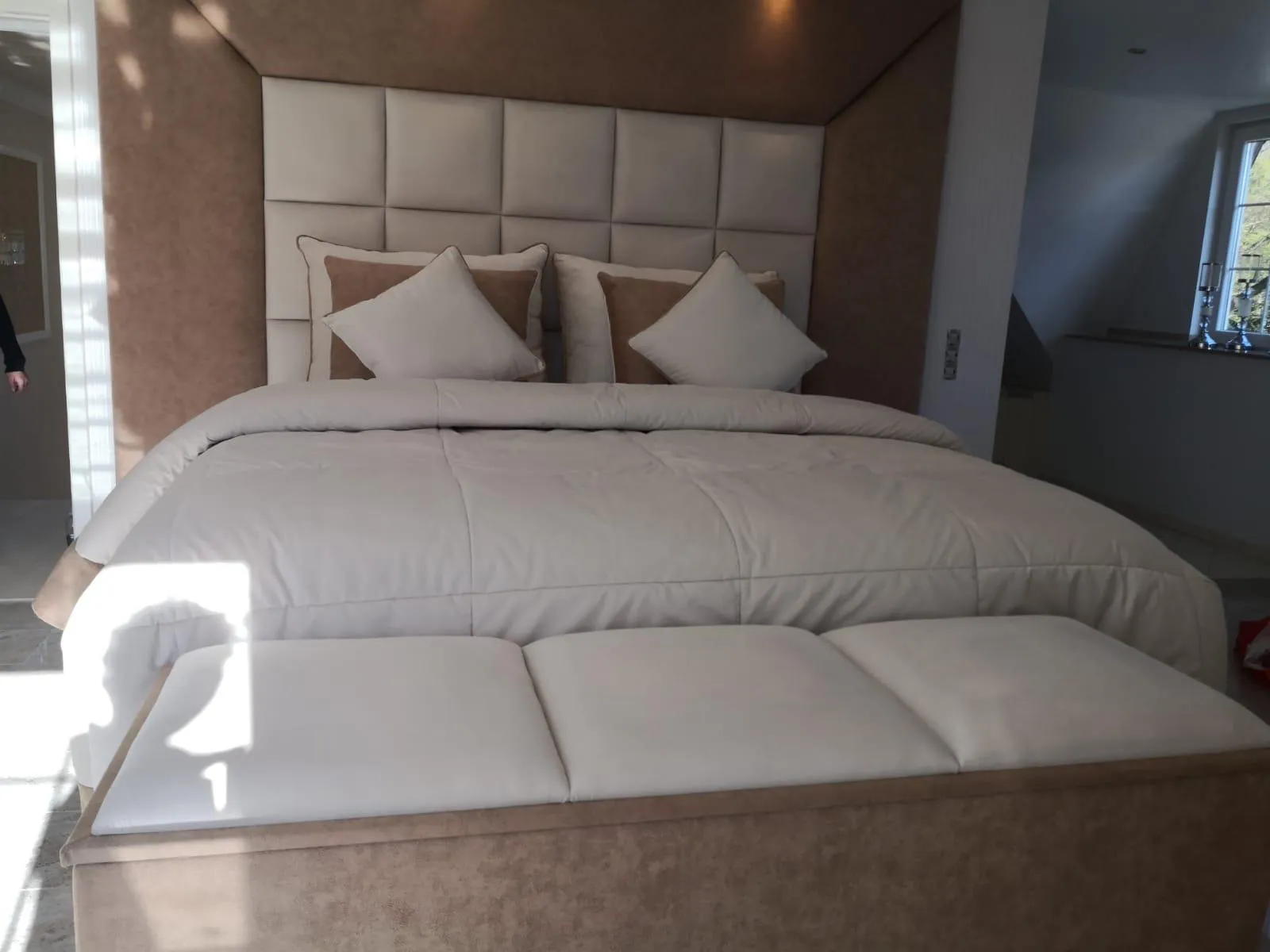 Gepolstertes Bett und Wandpaneel im Schlafzimmer